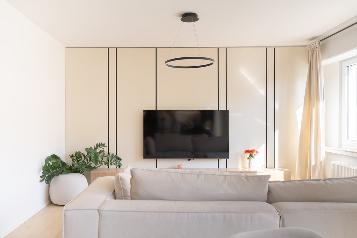 Coin salon avec télévision murale et suspension circulaire